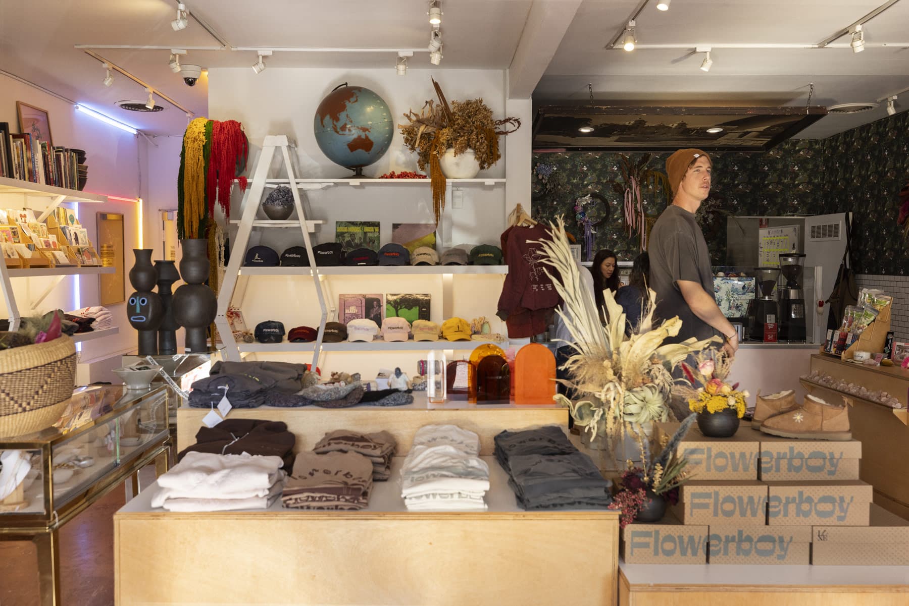 A shop owner arranging goods on a display table in a home goods store.