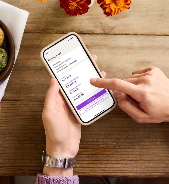 A phone showing the Homebase app reviewing payroll for Cheeseboat: 2 locations, 16 team members, pay period October 19 to October 25, payday Friday October 31.