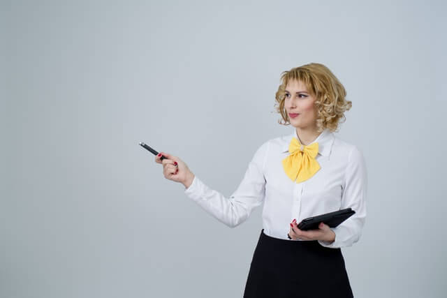woman dressed in business attire giving a presentation